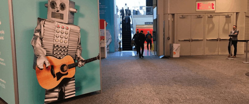 A robot with a guitar and a man staring at NRF 2016