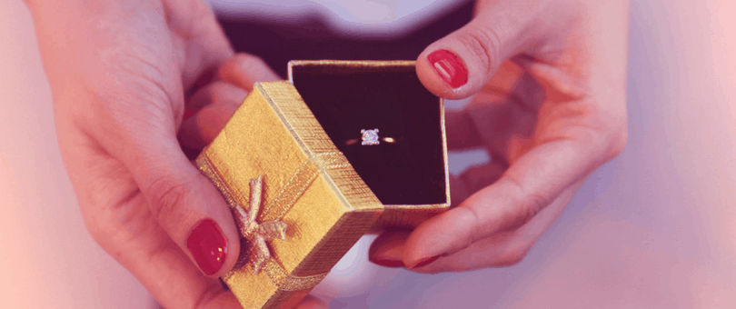 diamond ring in a box, held by hands, jewelers selling high-value items face Valentine's Day fraud challenges