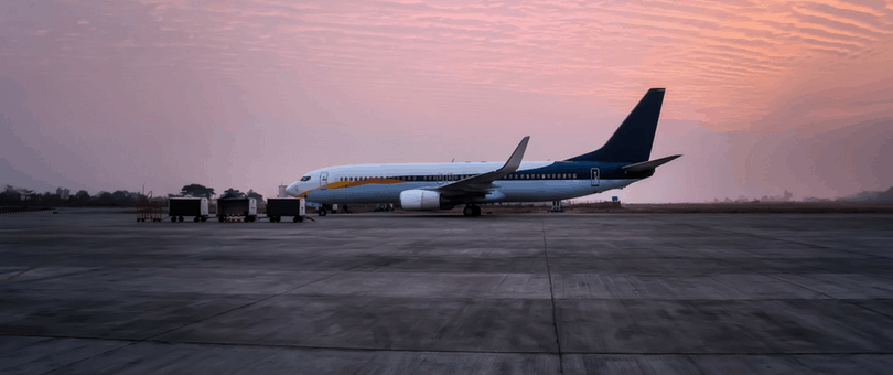 a plane on the runway at sunset, signifying global expansion