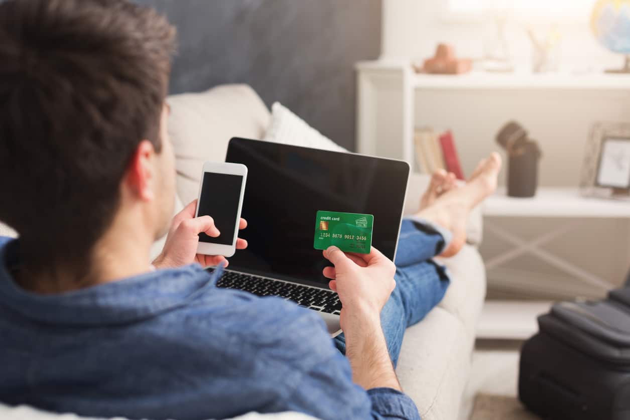 A consumer chilling on the couch while checking out online