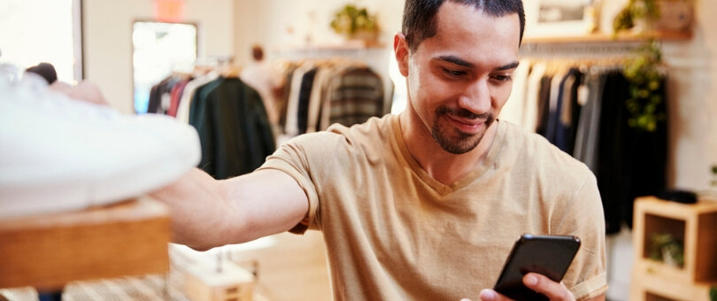A shopper looking at e-commerce on his phone