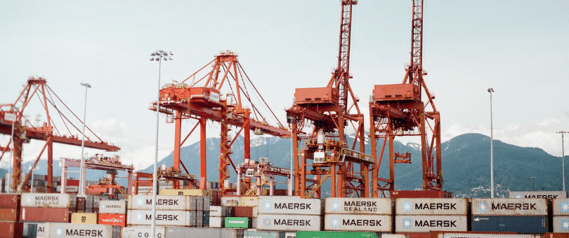 Shipping containers and cranes in a busy port.
