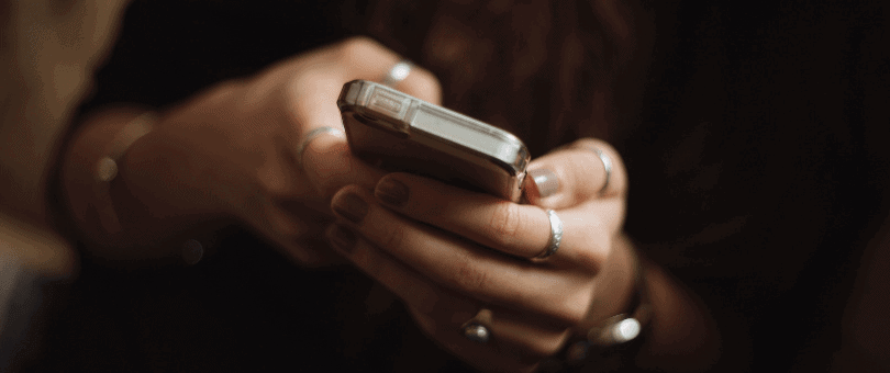 A woman's hand holding a smartphone