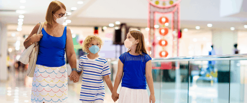 Family walking through a shopping mall wearing masks in the era of coronavirus