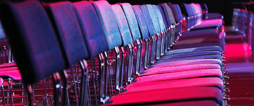 Rows of empty seats in a physical conference room