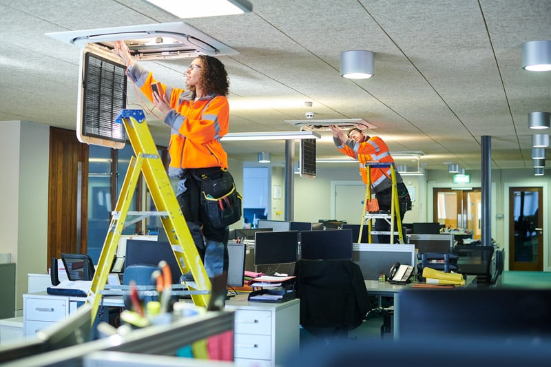 Workers changing light bulbs