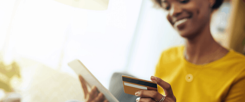 Woman shopping online, holding a tablet and a credit card