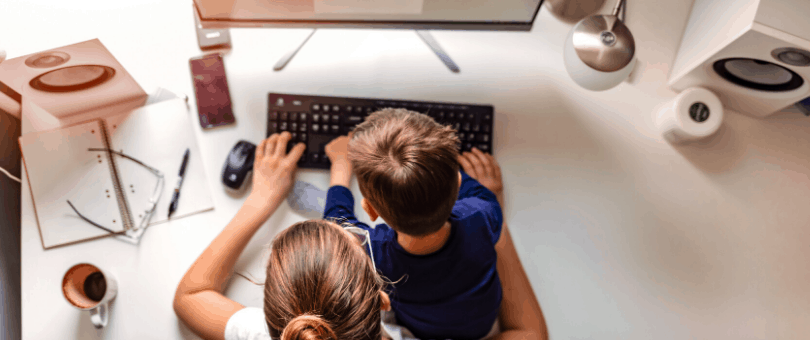 A woman working from home with a kid in her lap
