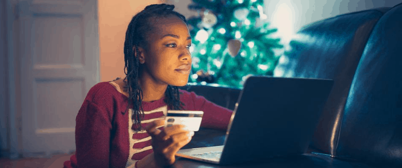 Woman holiday shopping in her home with Christmas tree in background