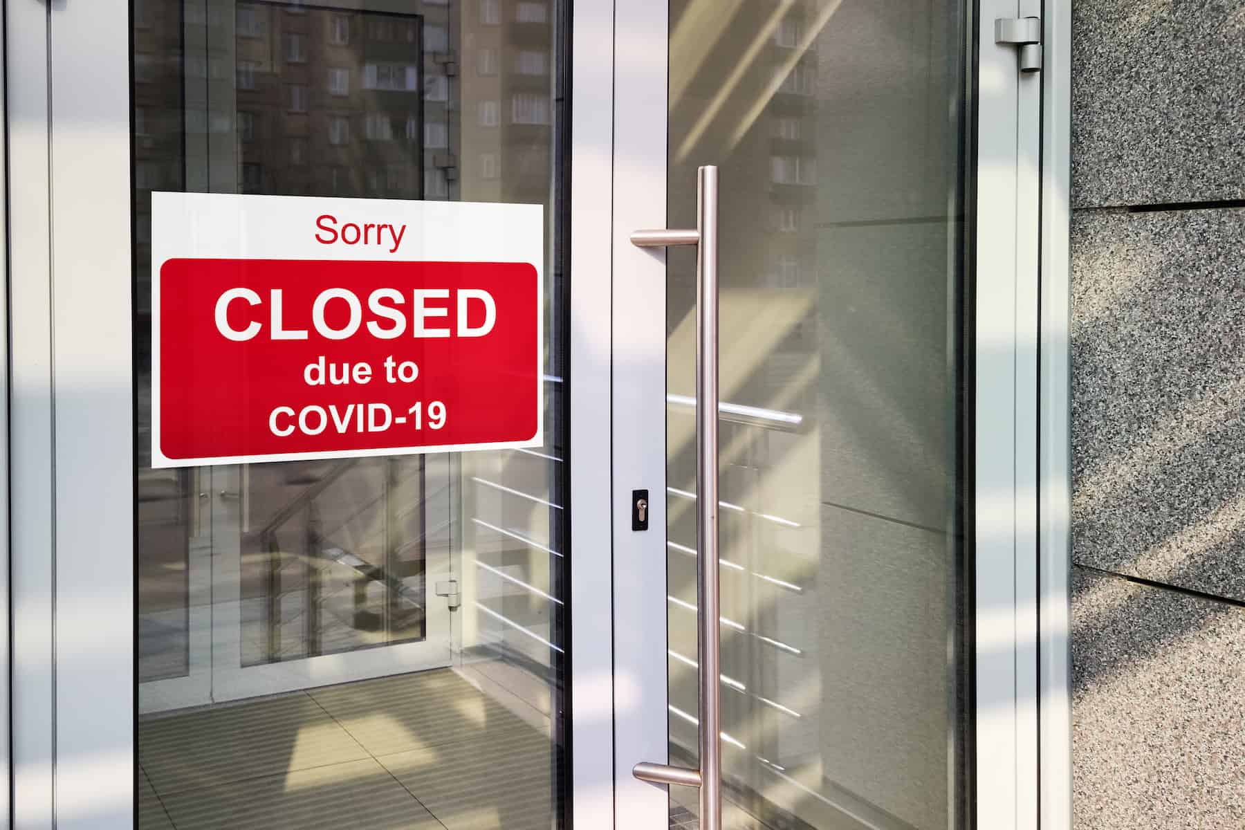 A store door with closed due to COVID on it