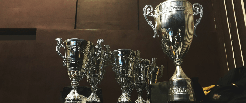 Several trophies in a dark room on a wooden surface