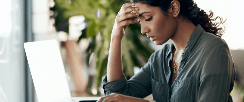 Woman at laptop, hand on forehead, frustrated shopping