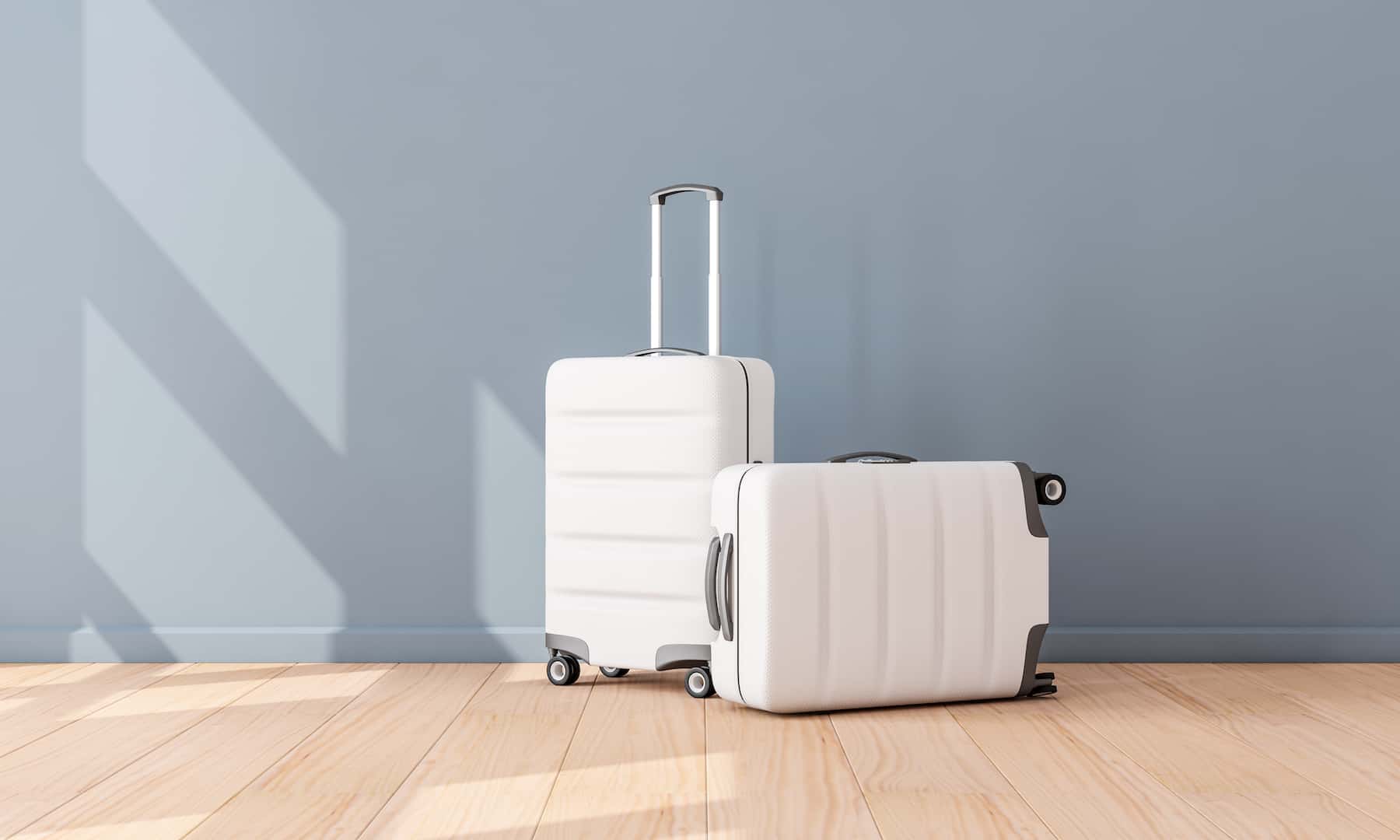two white suitcases in an empty room to illustrate Signifyd March Pulse data post