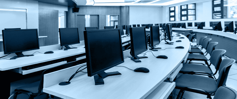 empty room with rows of tables with monitors on top, looking like an office being provisioned for an enterprise