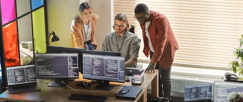 A team of fraud specialists exploring data on screens for use of AI in fraud detection blog post