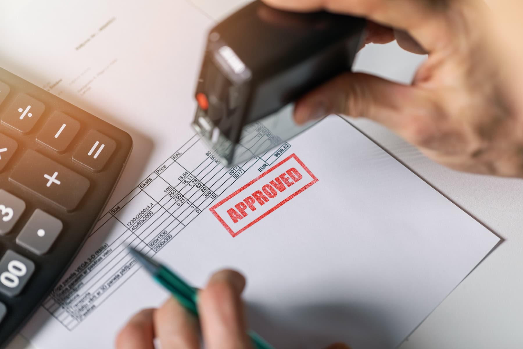 Legal looking document on a desk with a big, red stamp "Approved" to illustrate Signifyd's pre-authorization vs. post-authorization blog post.