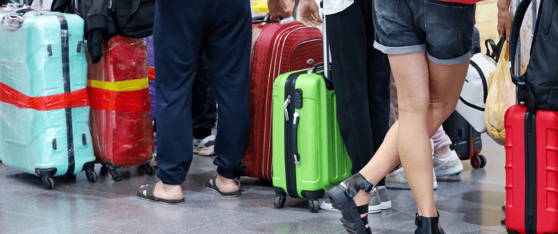 passengers with suitcases lined up in a busy airport to illustrate Signfyd Jeff Wixted's mission to move into airline vertical