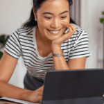 A smiling woman shopping on a laptop to illustrate Signifyd blog post about avoiding chargebacks with clear return policies