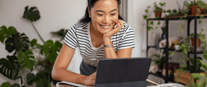 A smiling woman shopping on a laptop to illustrate Signifyd blog post about avoiding chargebacks with clear return policies