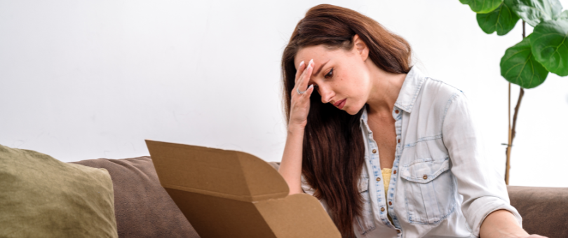 A woman clearly disappointed with an ecommerce order she just opened