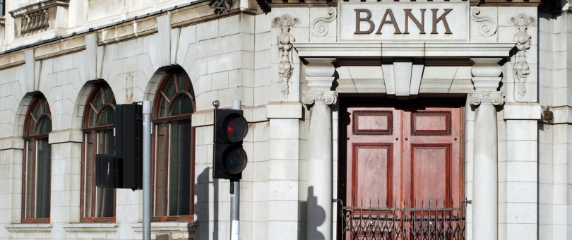 A classic bank facade with wooden door to illustrate Signifyd's post on improving bank authorization rates