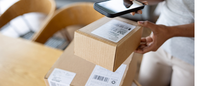 Photo of a woman scanning an ecommerce package with a phone, preparing to return the item