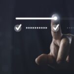 Photo of a hand, index finger extended, moving a a line from one check mark to another - symbolizing moving from approval to authorization