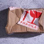 A crushed box labeled "Fragile" symbolizing post-purchase dissonance