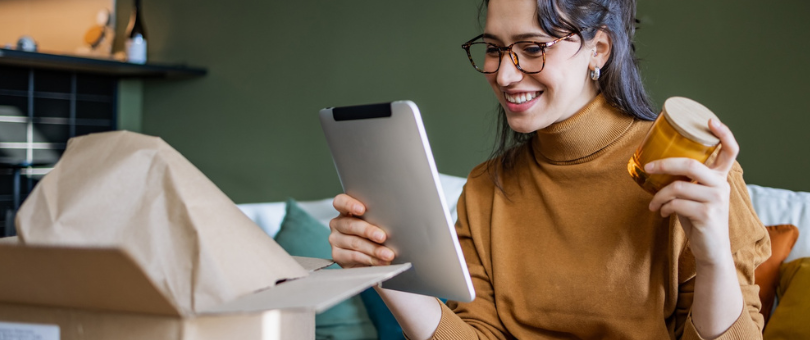 A woman obviously happy with a mug she received via delivery, her ecommerce post-purchase experience