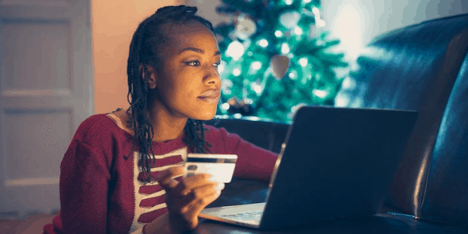 Woman holiday shopping in her home with Christmas tree in background