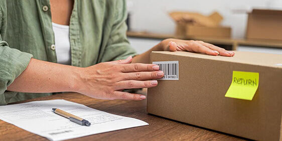 A woman prepares a package containing an ecommerce return for shipping back to the merchant