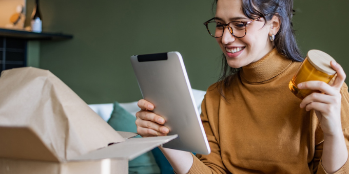 A woman obviously happy with a mug she received via delivery, her ecommerce post-purchase experience
