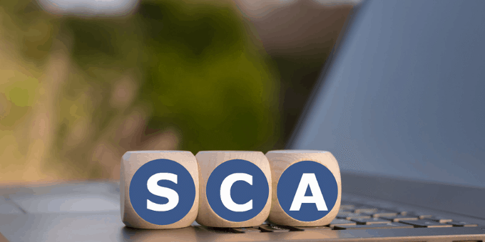 an open laptop with alphabet blocks spelling SCA, for strong customer authentication