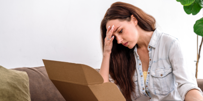A woman clearly disappointed with an ecommerce order she just opened