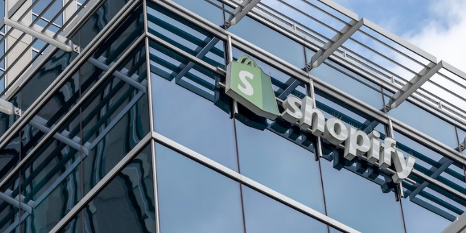 A picture of a Shopify sign on a modern, glass building in Ottawa