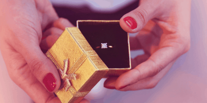 diamond ring in a box, held by hands, jewelers selling high-value items face Valentine's Day fraud challenges