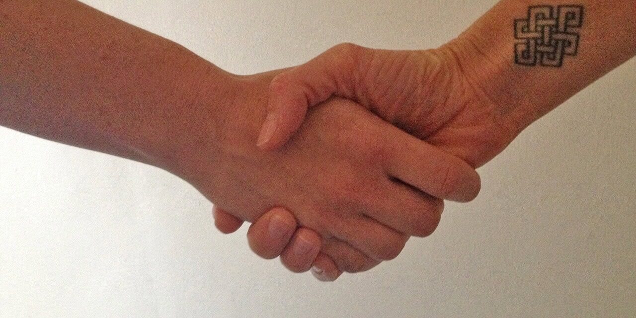 Two people shaking hands for Signifyd sales blog post