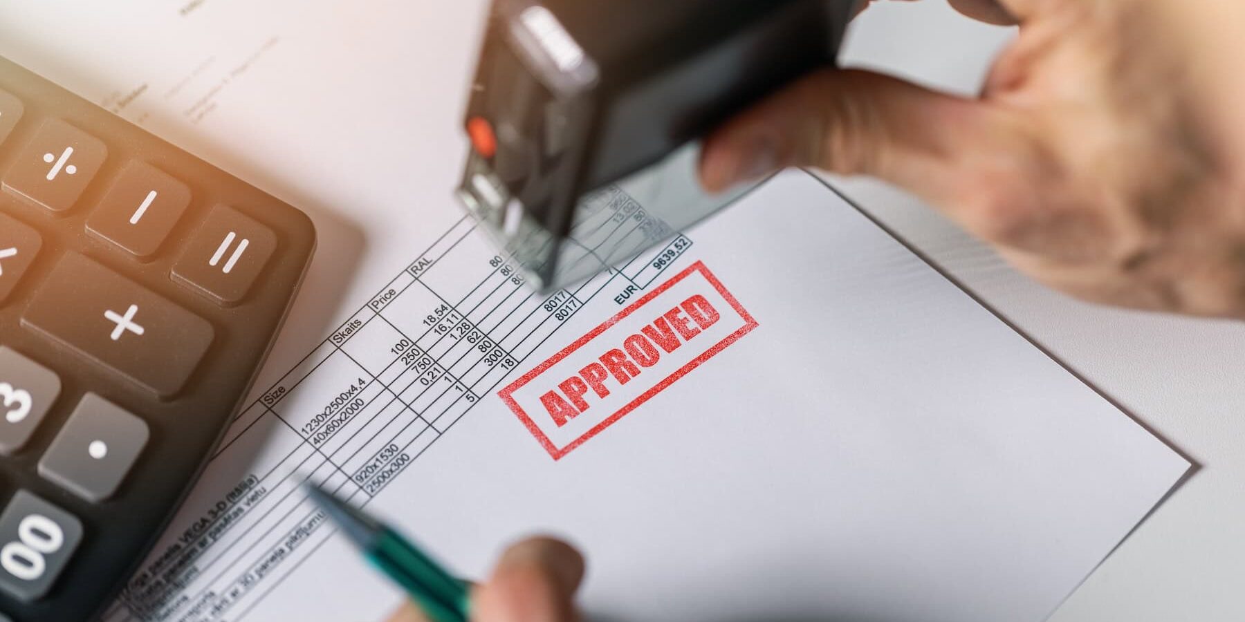 Legal looking document on a desk with a big, red stamp "Approved" to illustrate Signifyd's pre-authorization vs. post-authorization blog post.